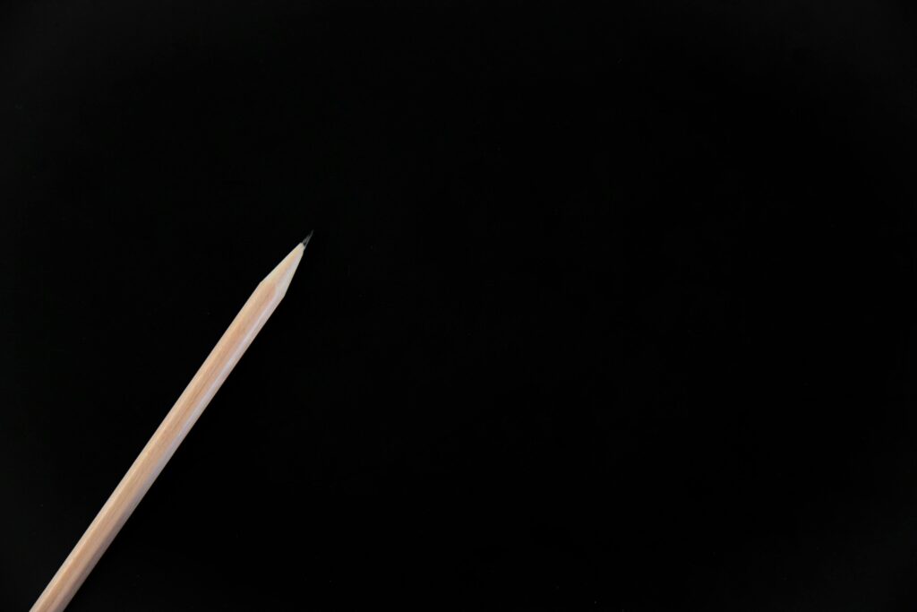 Minimalist image of a pencil on a black background, perfect for design projects.